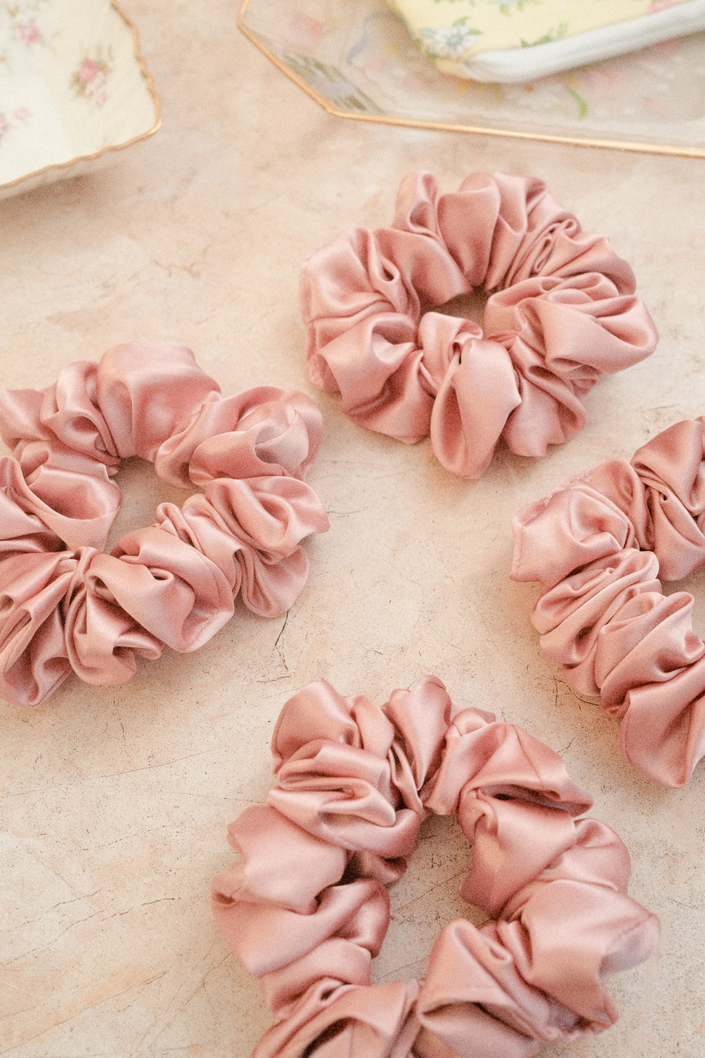 Pink scrunchies on a textured surface