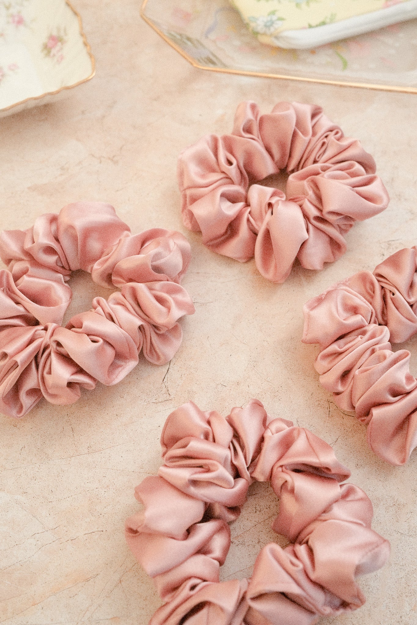 Pink scrunchies on a textured surface