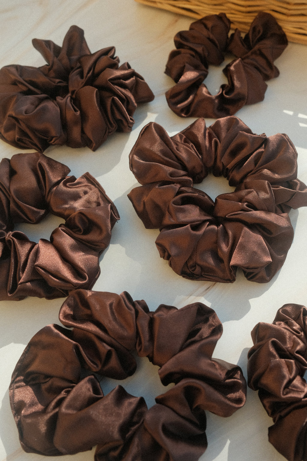 Brown satin scrunchies on a white background