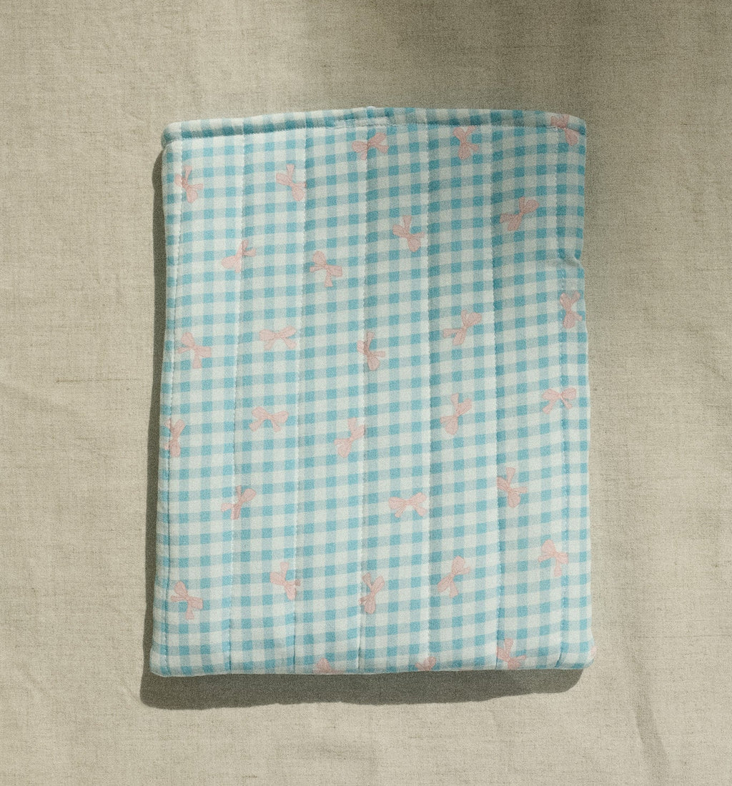 Folded fabric with blue and white checkered pattern on a beige surface