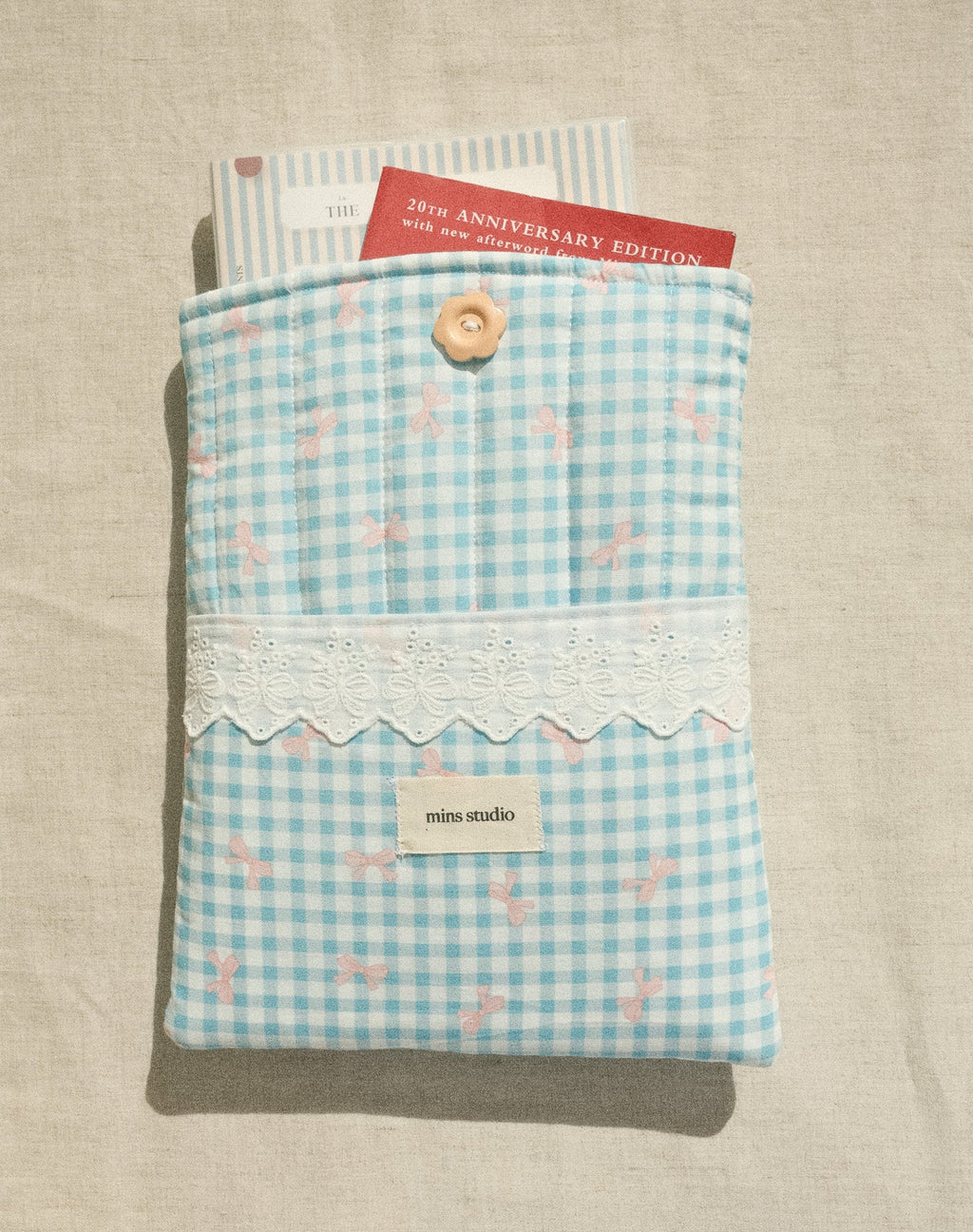 Blue checkered pouch with lace detail on a beige surface