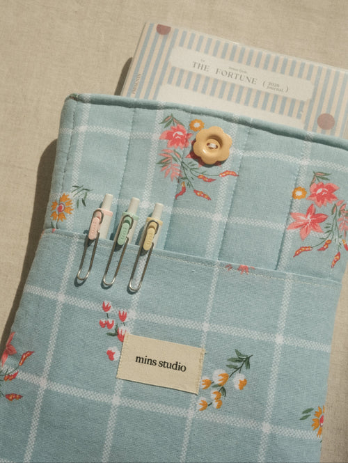 Floral-patterned fabric with buttons and a buttonhole on a textured surface