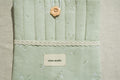 Sage book sleeve with a lace and brand label