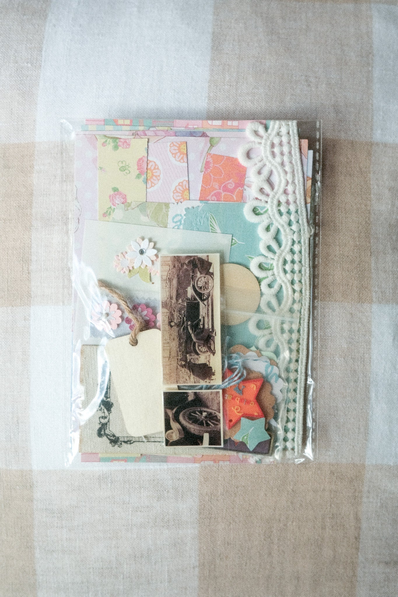 Decorative card with vintage car images and lace details on a checkered fabric background