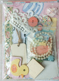 Packaging of decorative paper elements and embellishments on a checkered fabric background