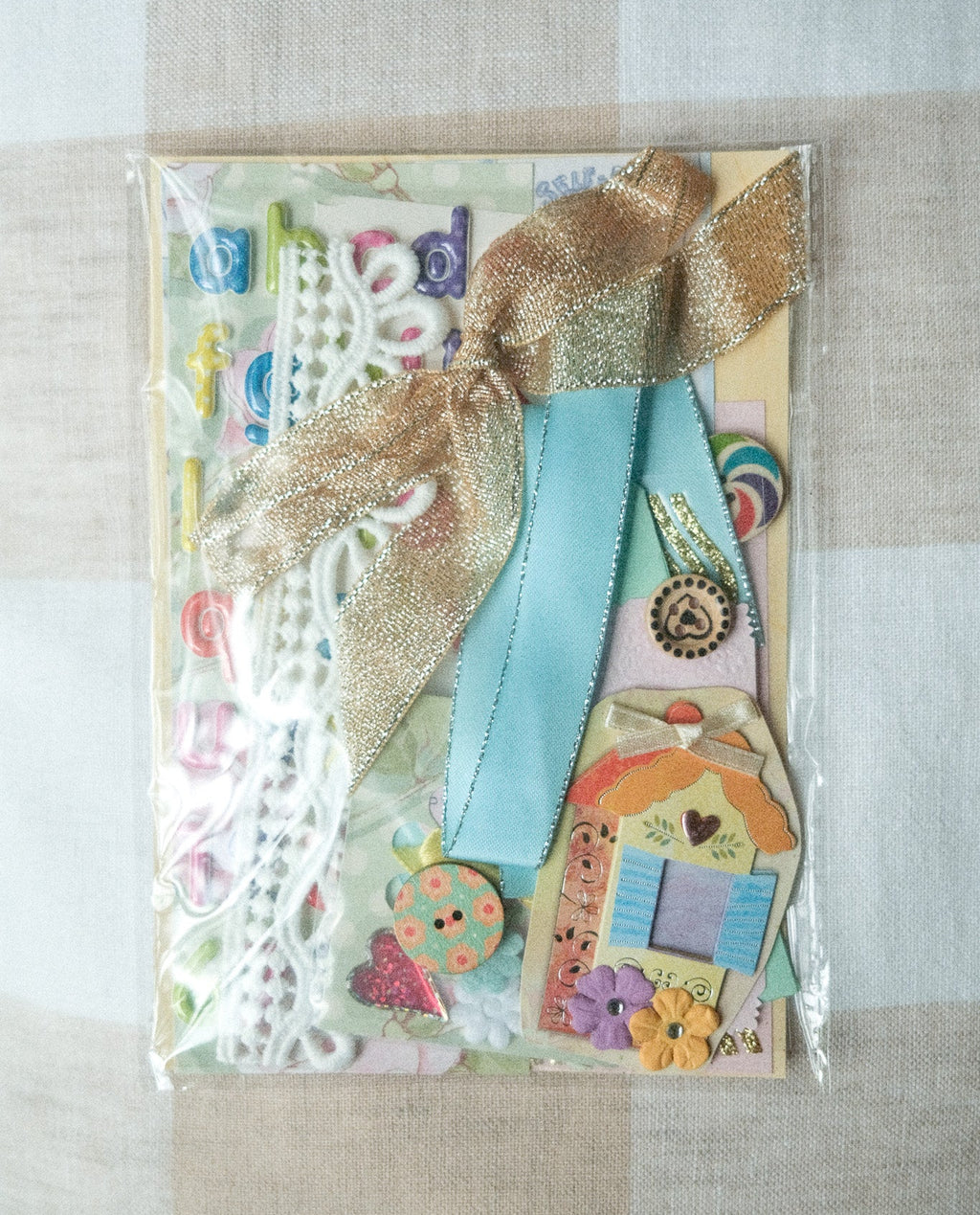 Decorative paper pack with ribbons and embellishments on a beige surface