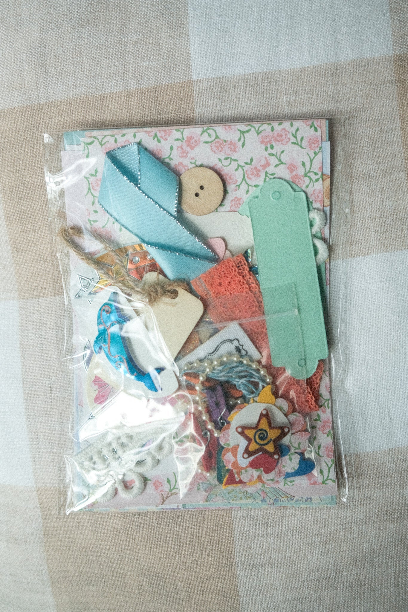 Packaged craft supplies with decorative elements on a checkered fabric background