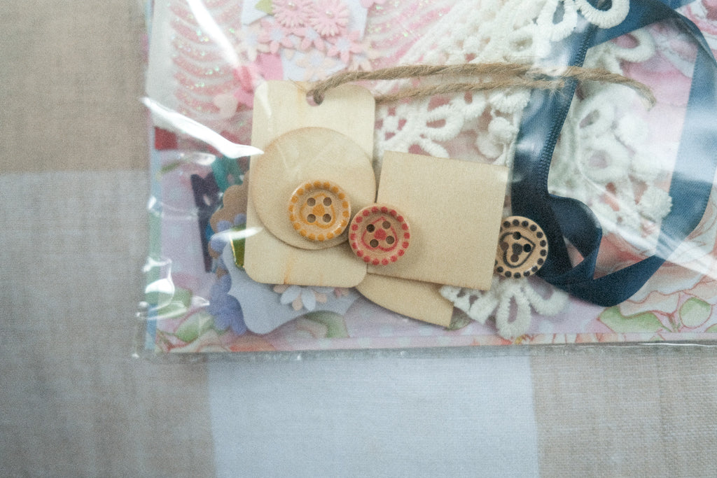 Collection of buttons and ribbons in a clear plastic bag on a textured surface
