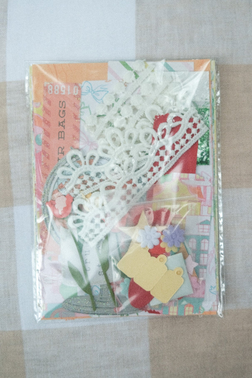 Decorative paper bags with floral designs on a checkered fabric background