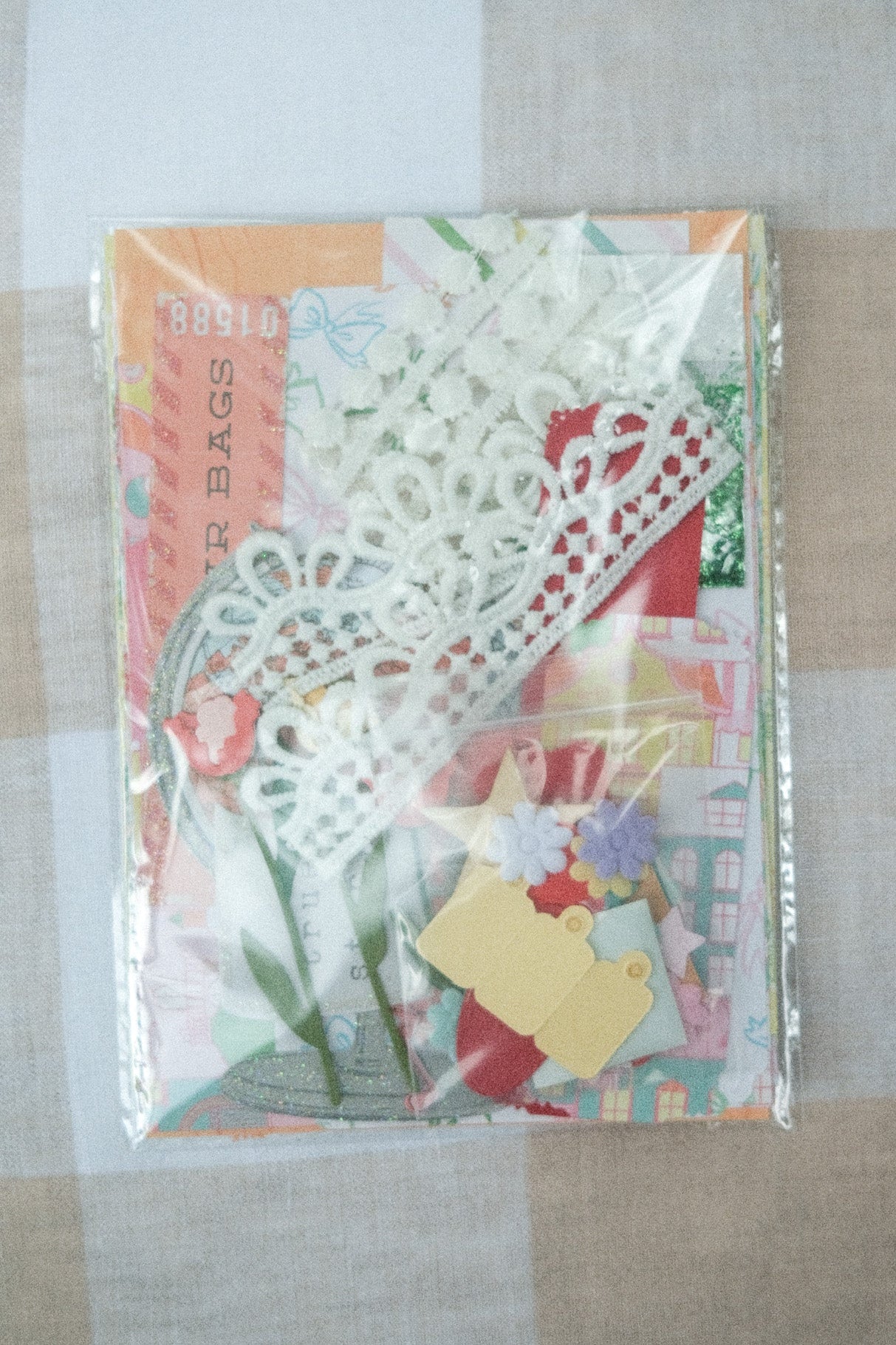 Decorative paper bags with floral designs on a checkered fabric background