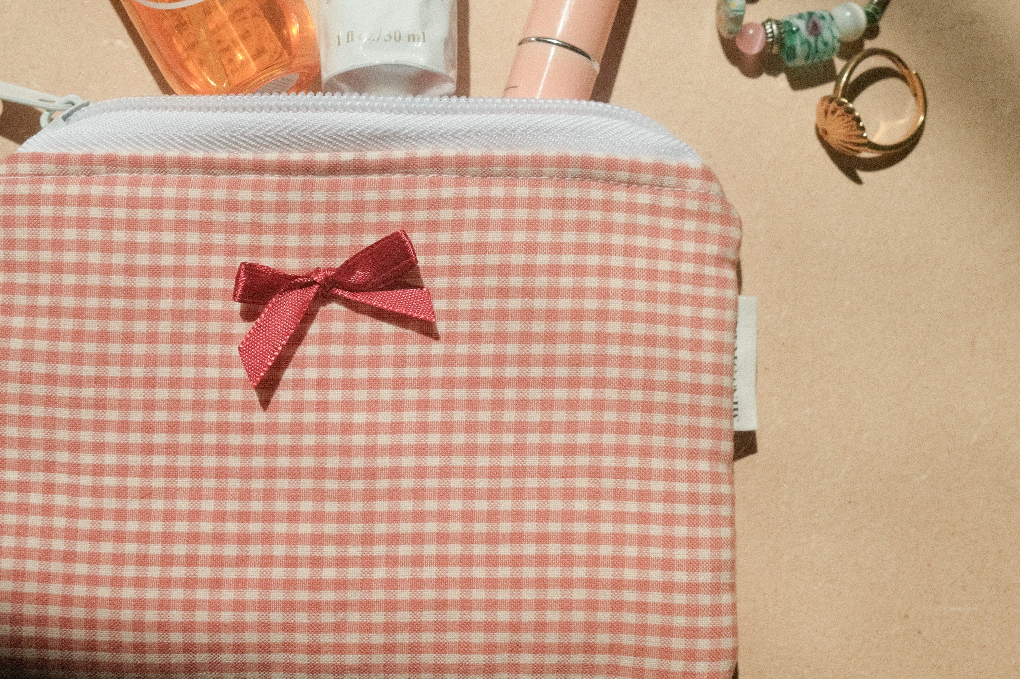 Checkered pouch with a red bow on a beige background