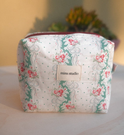 Floral patterned pouch with a visible brand label on a neutral background