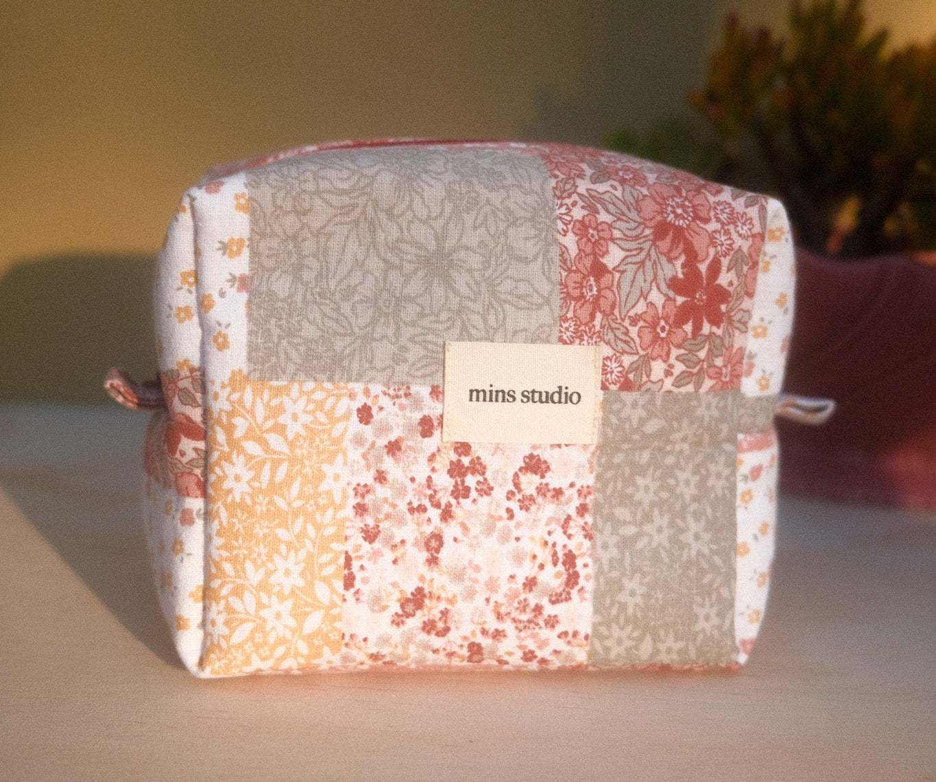 Patchwork pouch with floral patterns on a wooden surface